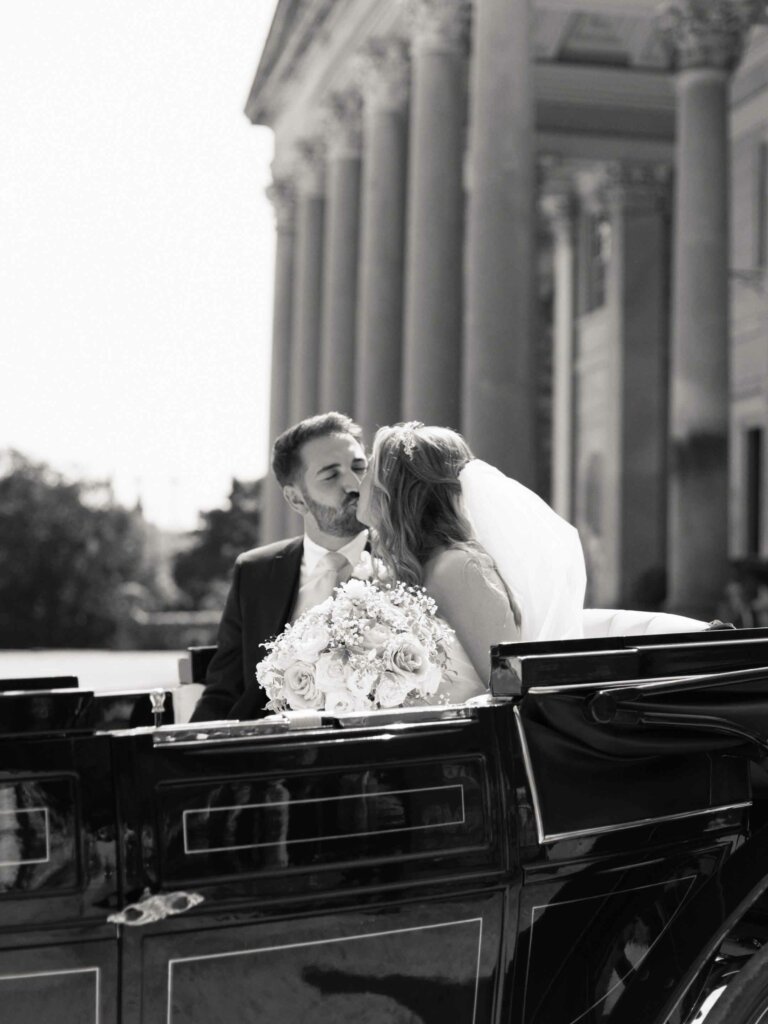 bride and groom kissing on a horse carriage